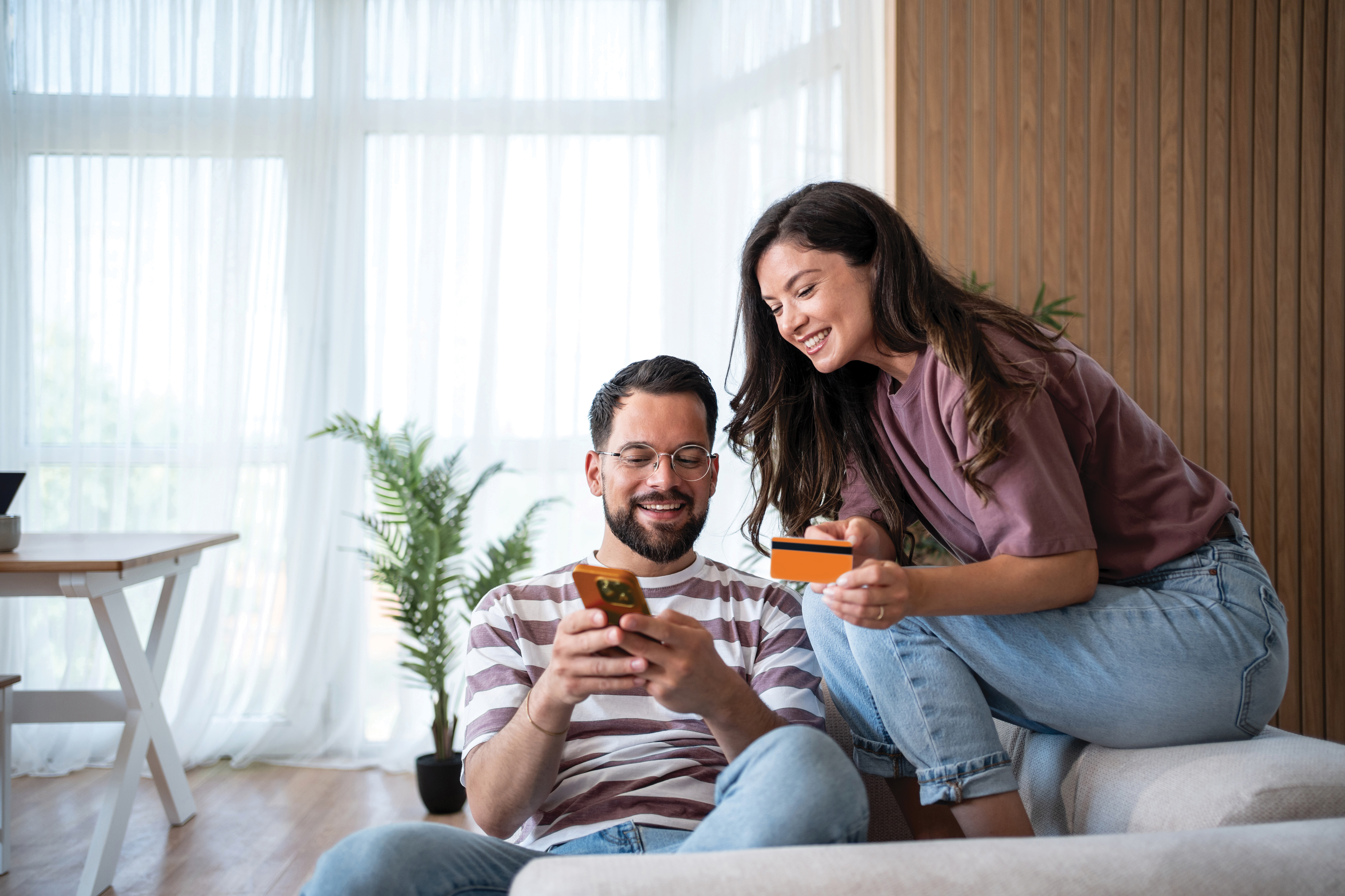 happy couple holding phone and card