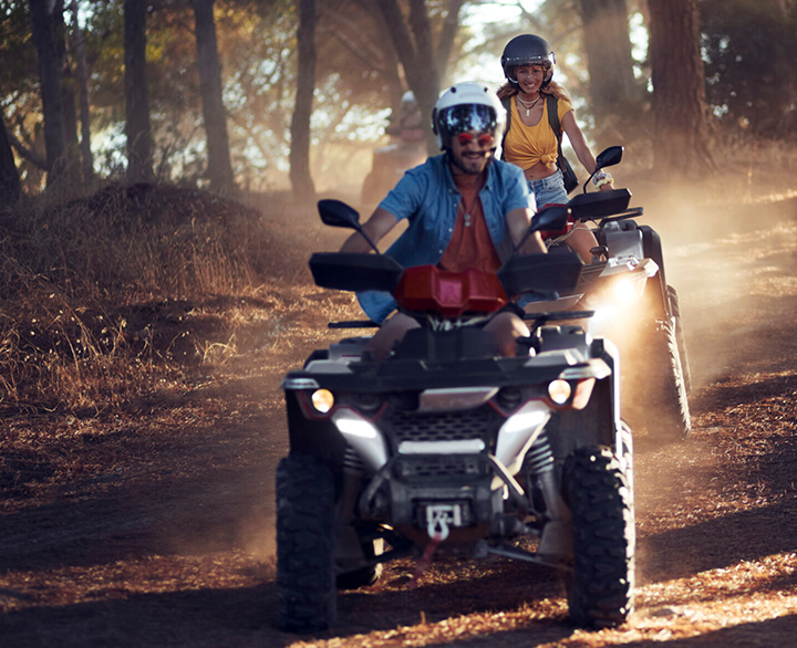 two people riding ATVs