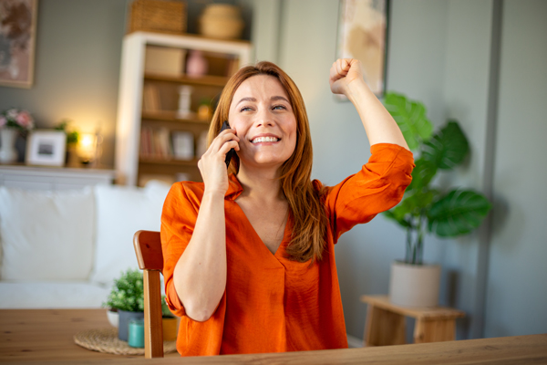 woman in home office with her fist up in celebration