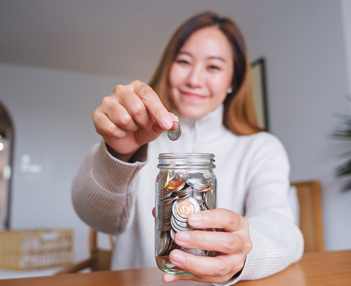 woman putting change into a change jar