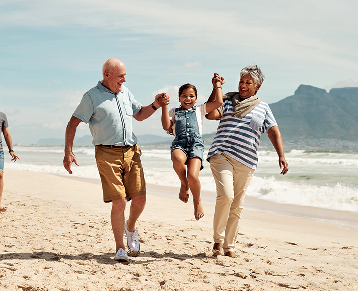 grandparents with child on a beach