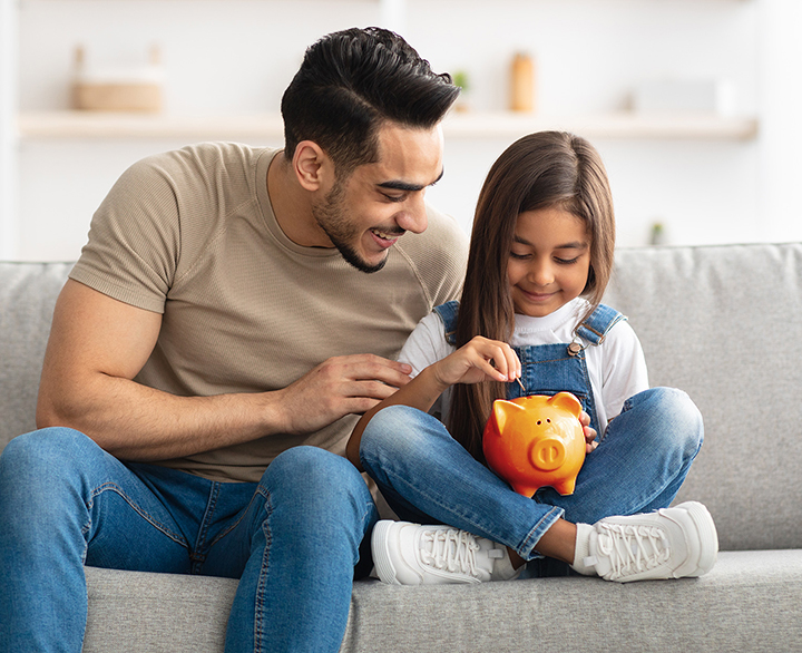 father and daughter holding a piggy bank