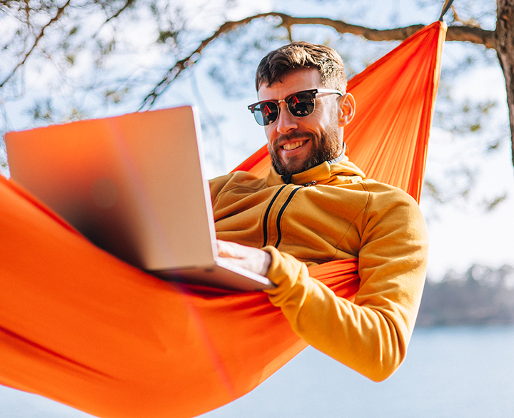 guy with a laptop in a hammock
