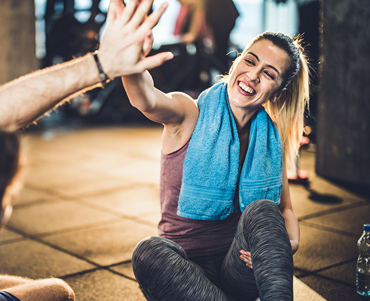 woman at the gym high-fiving a guy