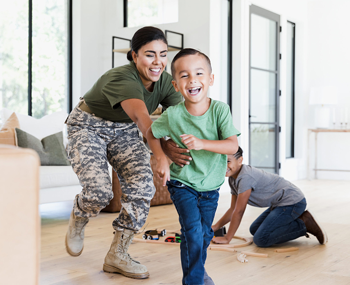woman in military uniform playing with kids