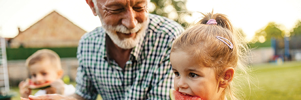 grandfather and granddaughter eating watermelon