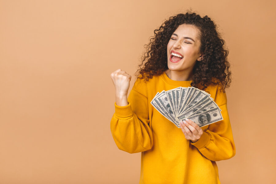 Portrait of a cheerful young woman holding money and celebrating her savings. Savings account or share certificate blog post.