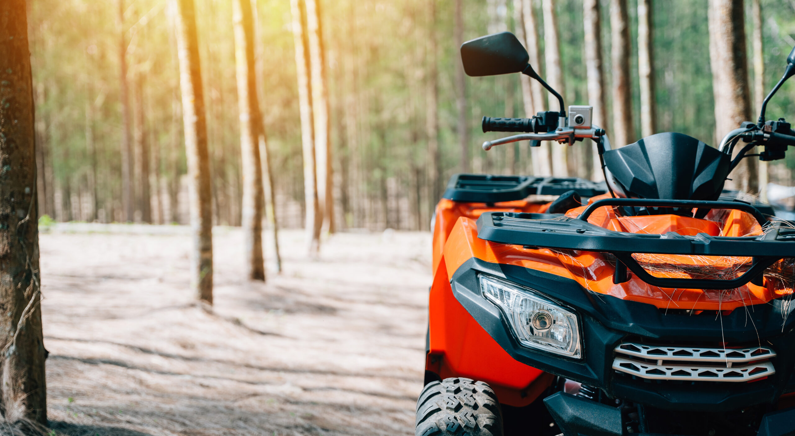 An offroad journey through the desert on a summer evening, with an ATV and UTV crossing sand dunes and mountains in the distance, close up Extreme recreation activity concept